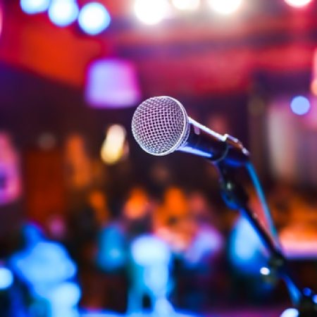 Public performance on stage Microphone on stage against a background of auditorium. Shallow depth of field. Public performance on stage.